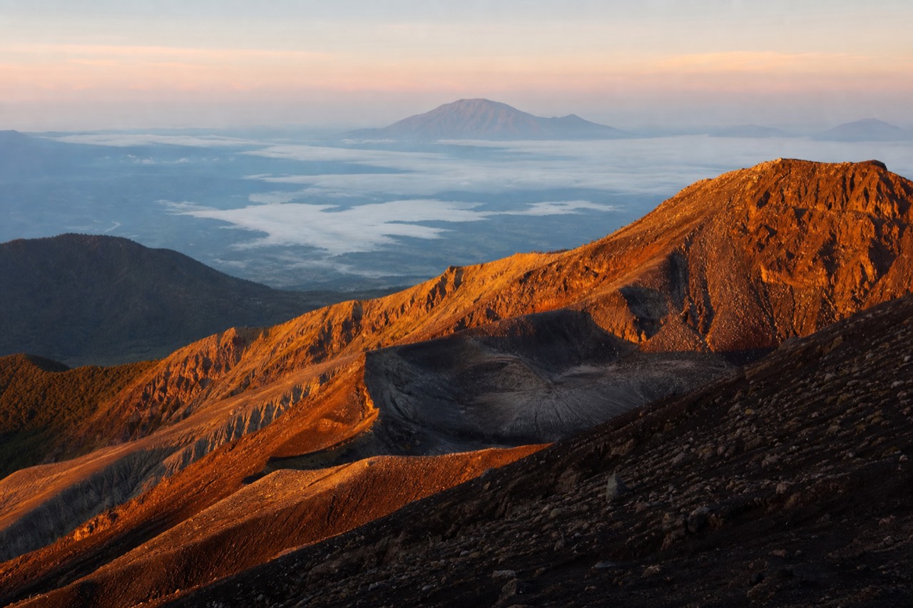 First light striking the crater rim of Santa Ana Volcano with the turquoise lake still in shadow below