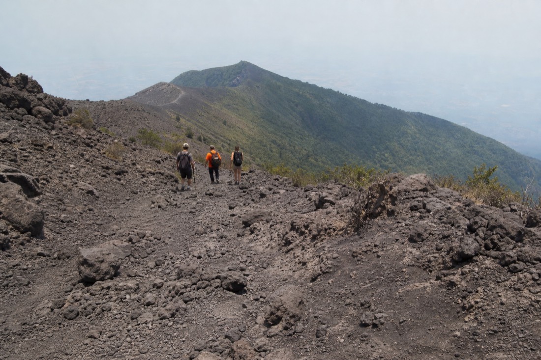 Hikers on the rocky upper trail of Santa Ana Volcano approaching the crater rim on the guided group ascent